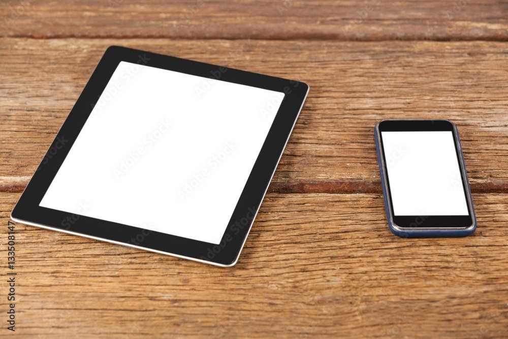 Digital tablet and smartphone on wooden plank Digital tablet and smartphone on wooden plank