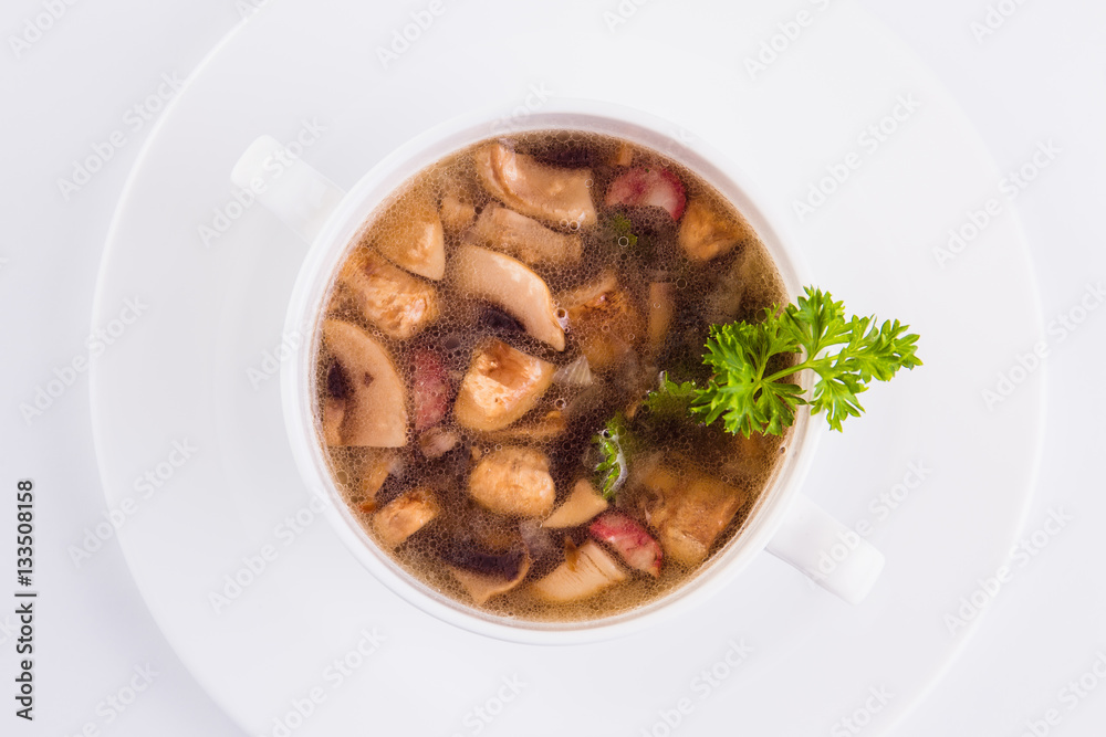 Mushroom soup in a circular plate on a white background Mushroom soup in a circular plate on a white background