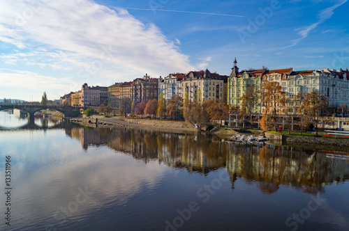 Coastline in Prague. Vltava river mirror reflaction in warm autumn light cloudy morning