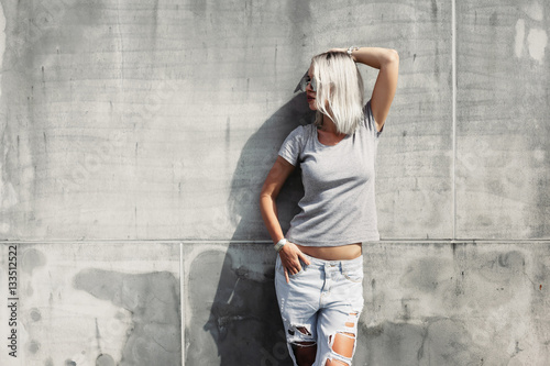 Hipster girl in gray t-shirt over street wall