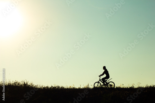 Silhouette of a female cyclist riding Movement on the background