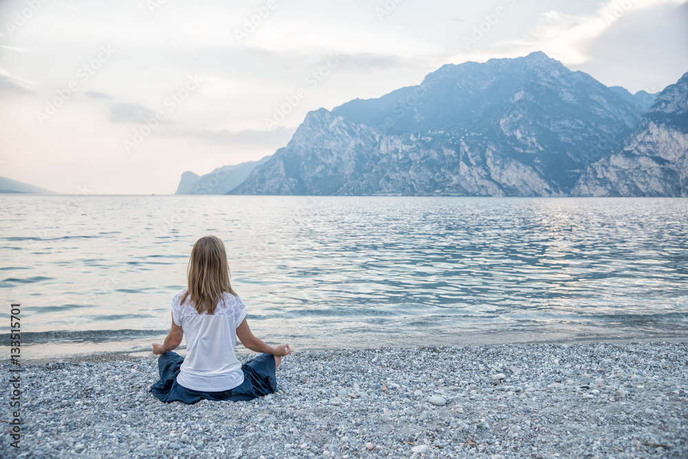 Woman meditating at the lake