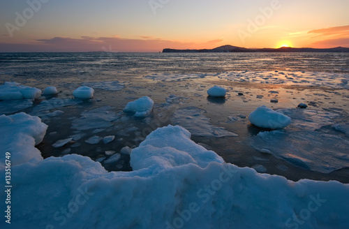 Sunset on the ice, winter coast