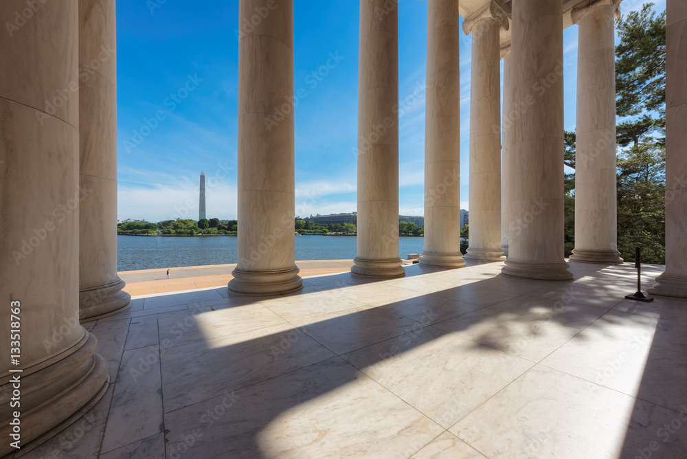 Columns at the Jefferson Memorial and the Washington monument on the horizon in Washington DC. Columns at the Jefferson Memorial and the Washington monument on the horizon in Washington DC.