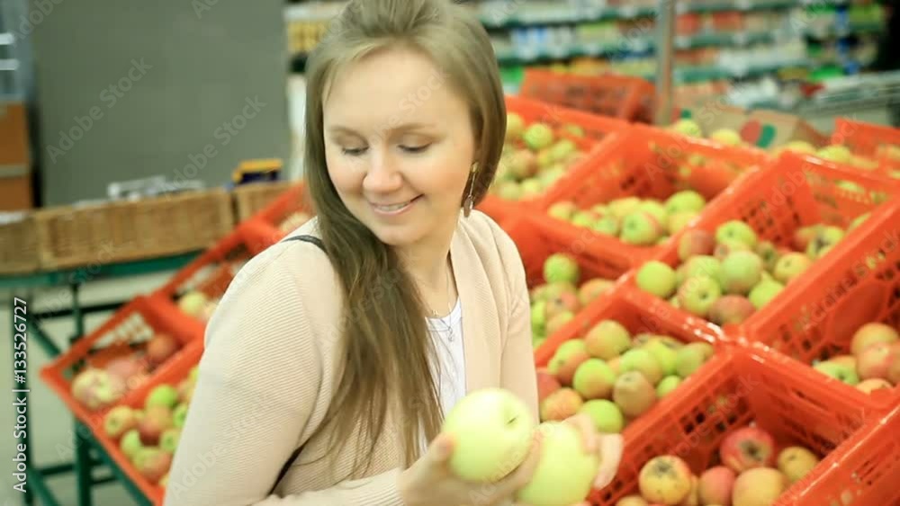 Beautiful lady choose fruit apples in store Beautiful lady choose fruit apples in store