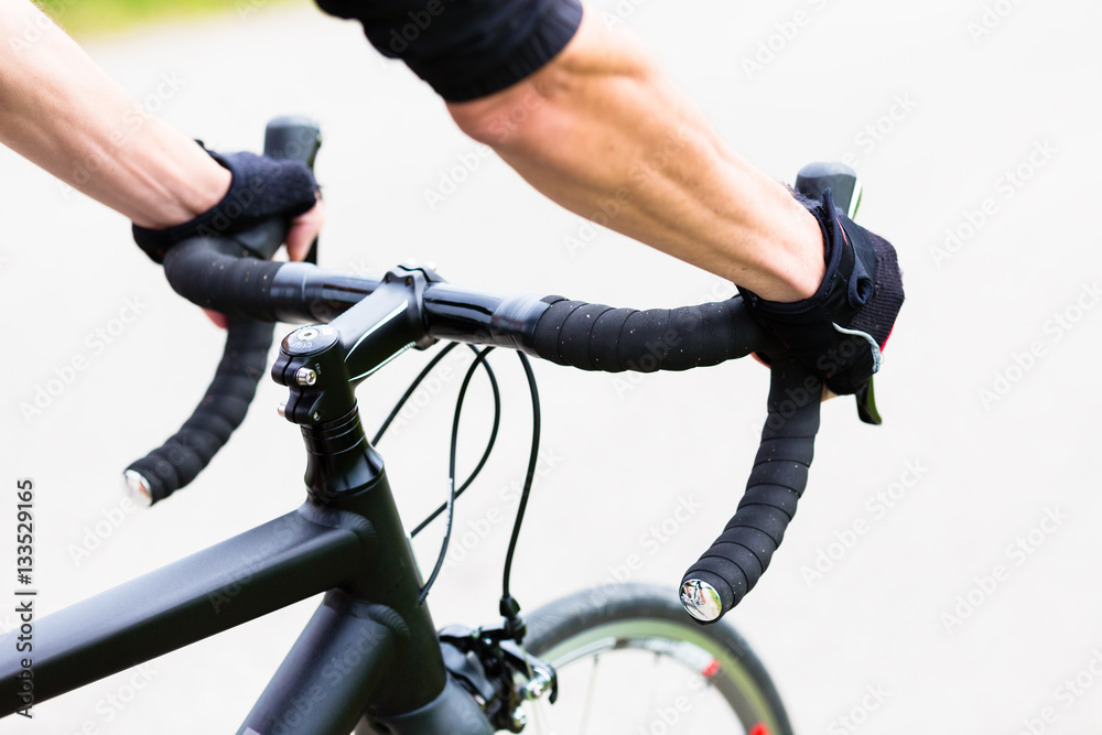 Fototapeta premium Sportler hat Hände am Lenker eines Rennrades, Rennlenker, Detail