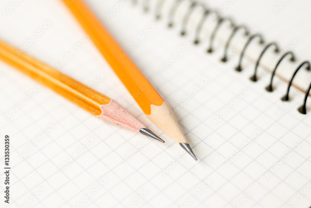 Pencils on the pages of an open notebook for records Pencils on the pages of an open notebook for records