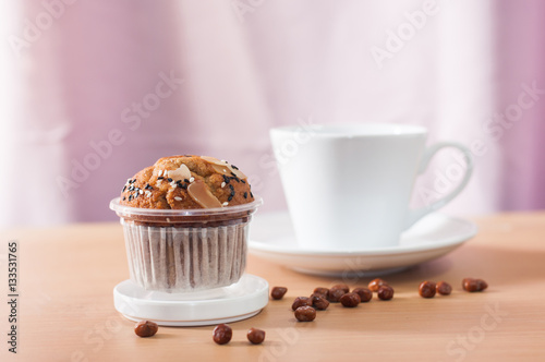 Cup cake and coffee cup on wooden desk,soft focus.