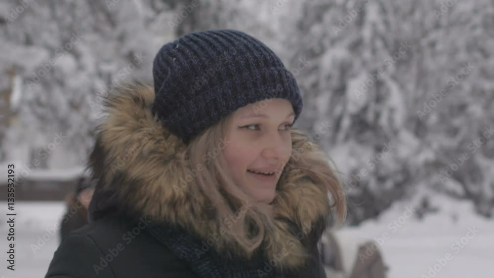 Happy young woman playing with snow