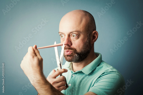 Worried bearded middle-aged  man with long nose isolated on blue photo