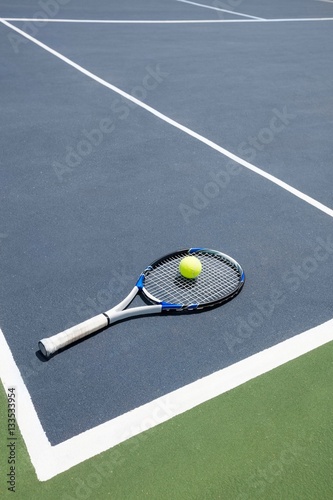 Tennis racquet and ball in court