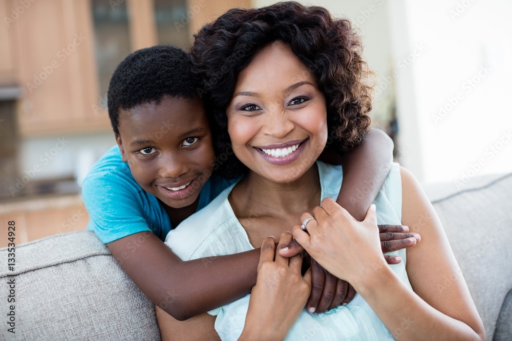 Portrait of mother and son embracing each other in living room Portrait of mother and son embracing each other in living room