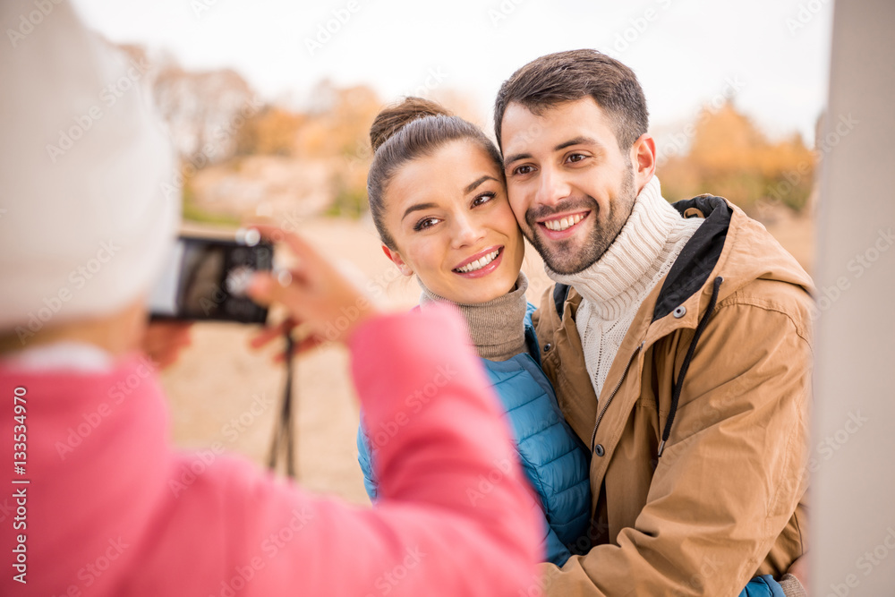 Girl photographing beautiful smiling couple Girl photographing beautiful smiling couple