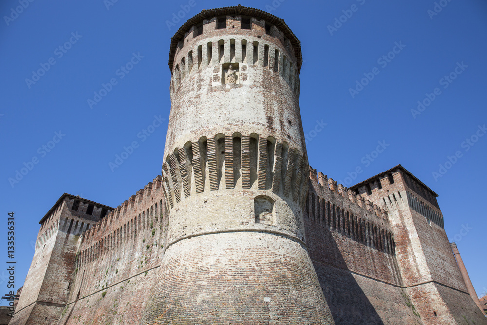Tower of medieval italian castle on blue sky