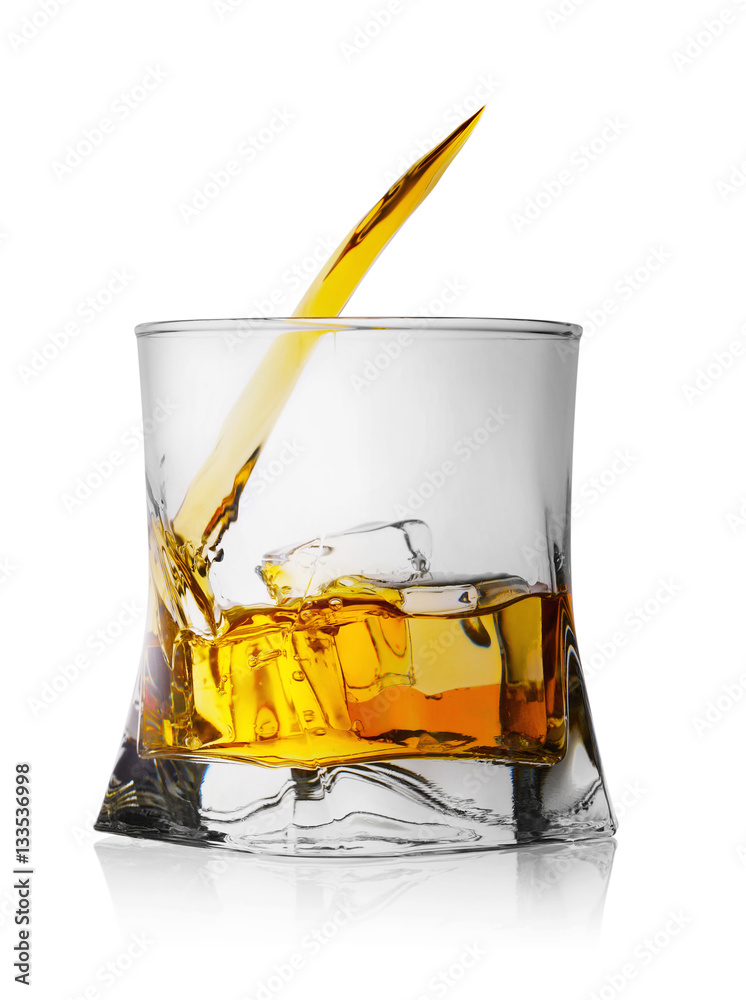 Splash of whiskey with ice in glass Splash of whiskey with ice in glass