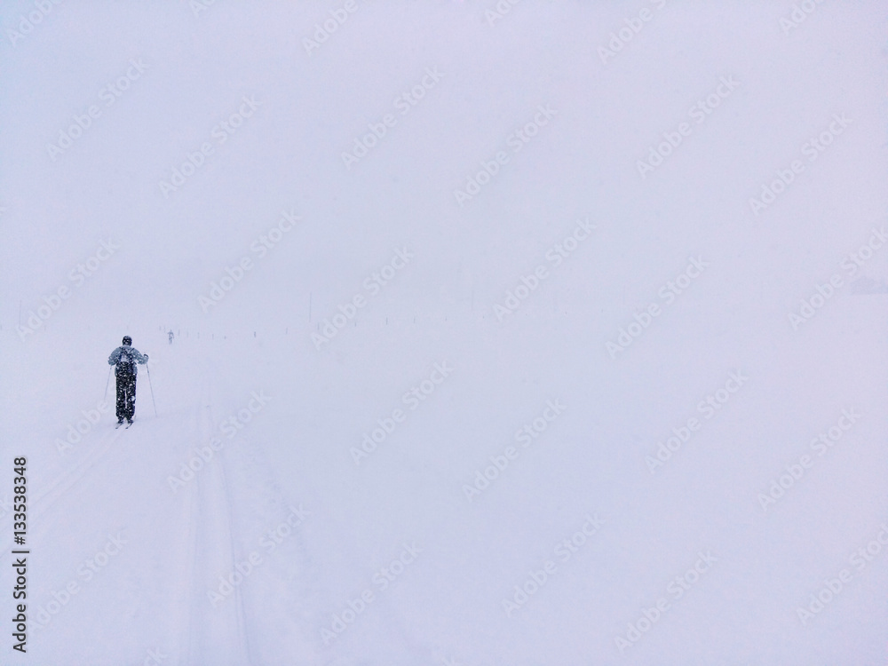 Langläufer auf der Loipe im Schneetreiben Langläufer auf der Loipe im Schneetreiben
