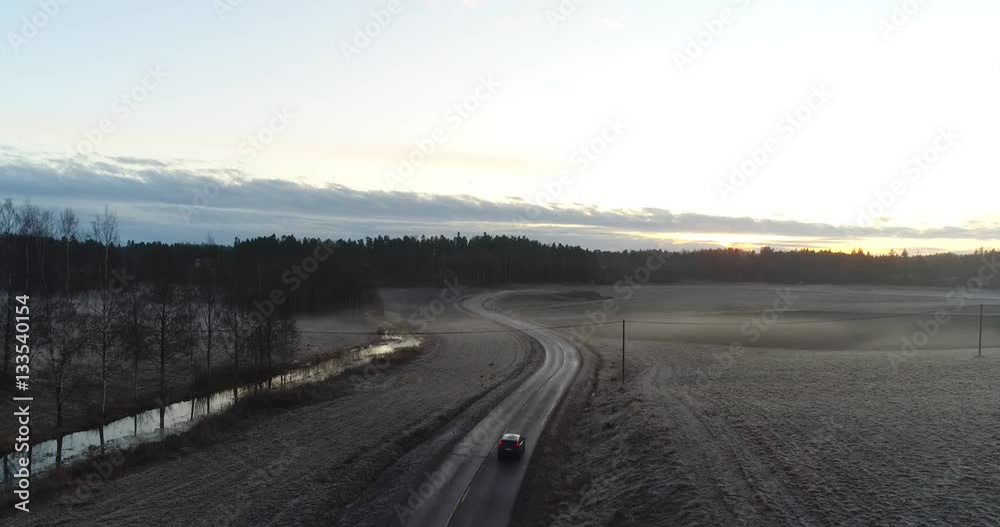 Cinema 4k aerial tilt view above a car on a slippy road, at foggy fields, at a cold evening sunset, in Snappertuna, Raasepori, Finland Cinema 4k aerial tilt view above a car on a slippy road, at foggy fields, at a cold evening sunset, in Snappertuna, Raasepori, Finland