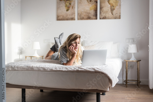 young women with the computer on bed photo