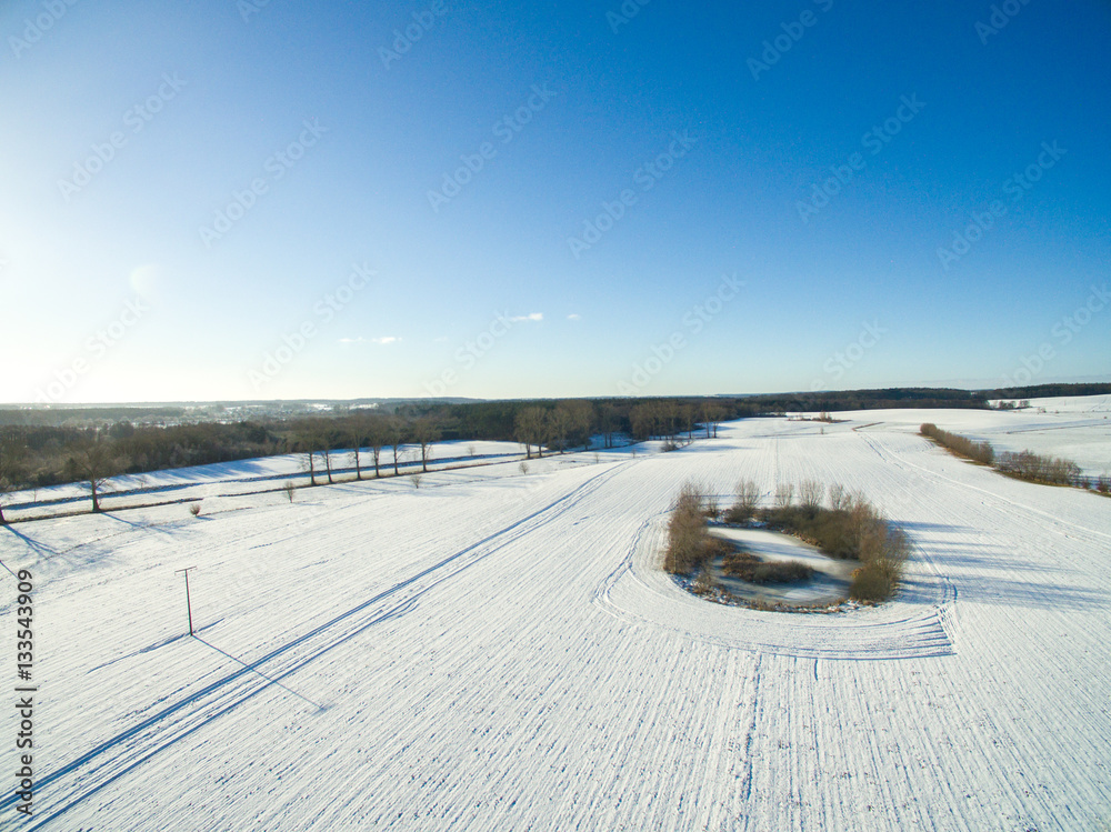 aerial view of snowy fields with blue sky in germany