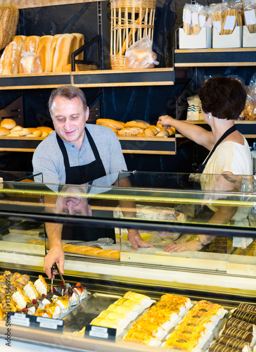 two bakers at the counter at bakery.