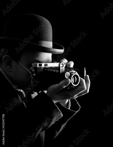 Young and attractive photographer in vintage suit and with retro