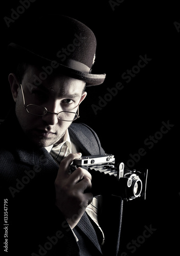 Young and attractive photographer in vintage suit and with retro