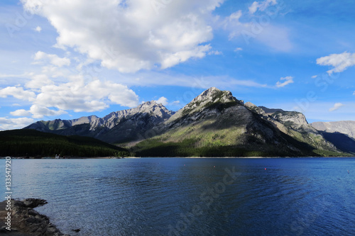 A distant landscape with a crystal clear lake surrounded by nature and a mountain. Banff, Alberta, Canada.