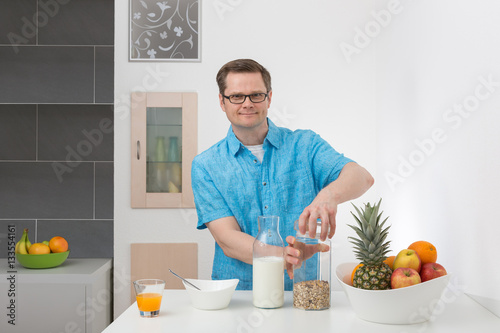 Mann frühstückt Müsli mit Milch photo