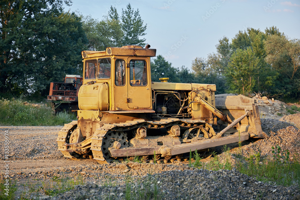 Yellow crawler tractor in  gravel canyon