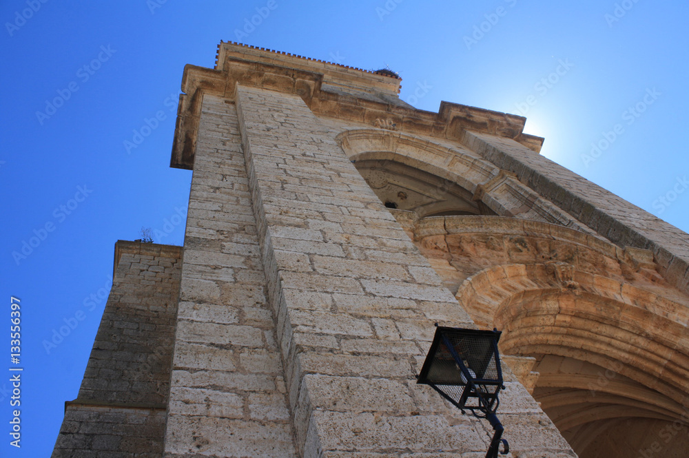 Campanario y entrada de Iglesia de un pueblo español, ocultando el sol Campanario y entrada de Iglesia de un pueblo español, ocultando el sol