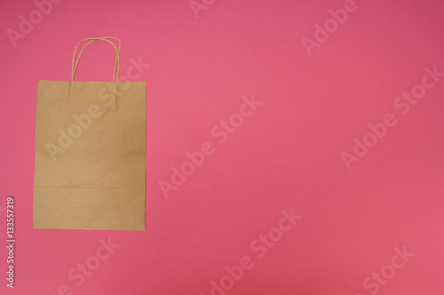 Disposable paper bag on pink background.