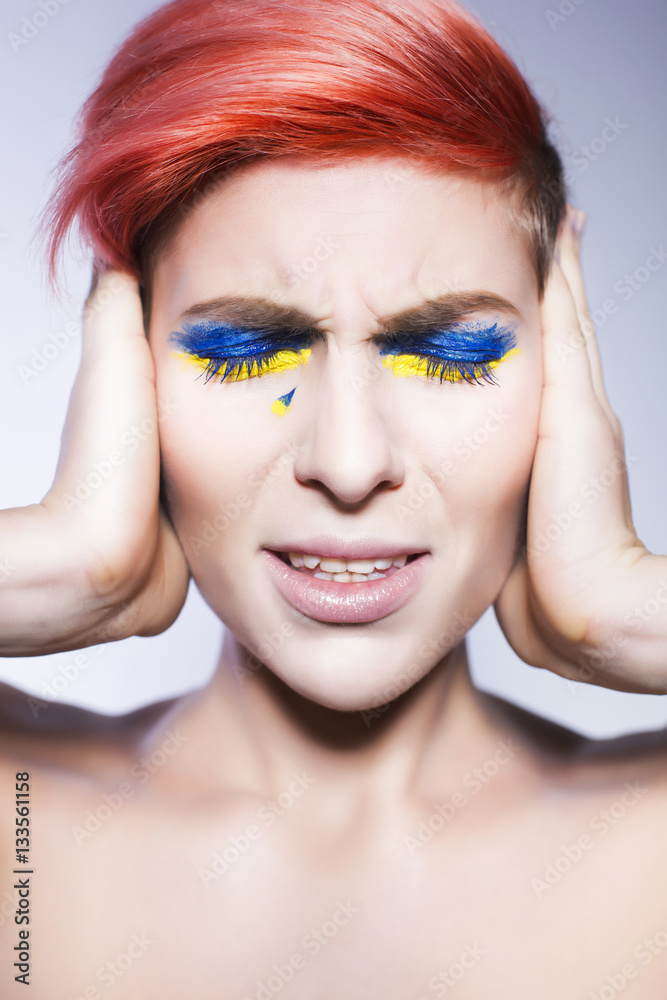 Young person closing ears and don't want to listen political lies crying. Ukrainian symbols and colors Young person closing ears and don't want to listen political lies crying. Ukrainian symbols and colors