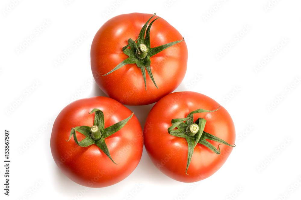 three realistic looking tomatoes lying in a triangle isolated in