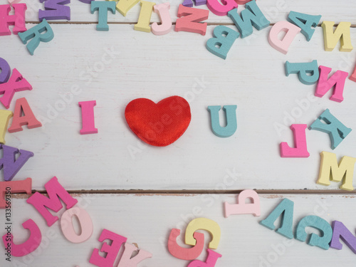 Vanlentine's day concept. Wooden color letters word love and red heart on color background with copy space.watering can love concept.