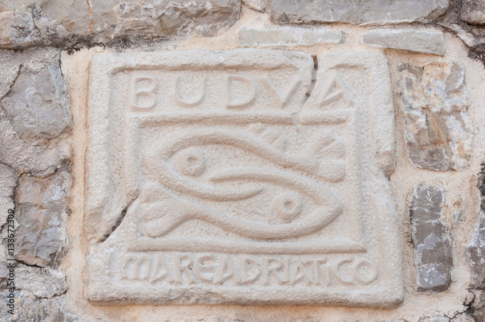 Historical sign of Budva city on stone wall, Montenegro.