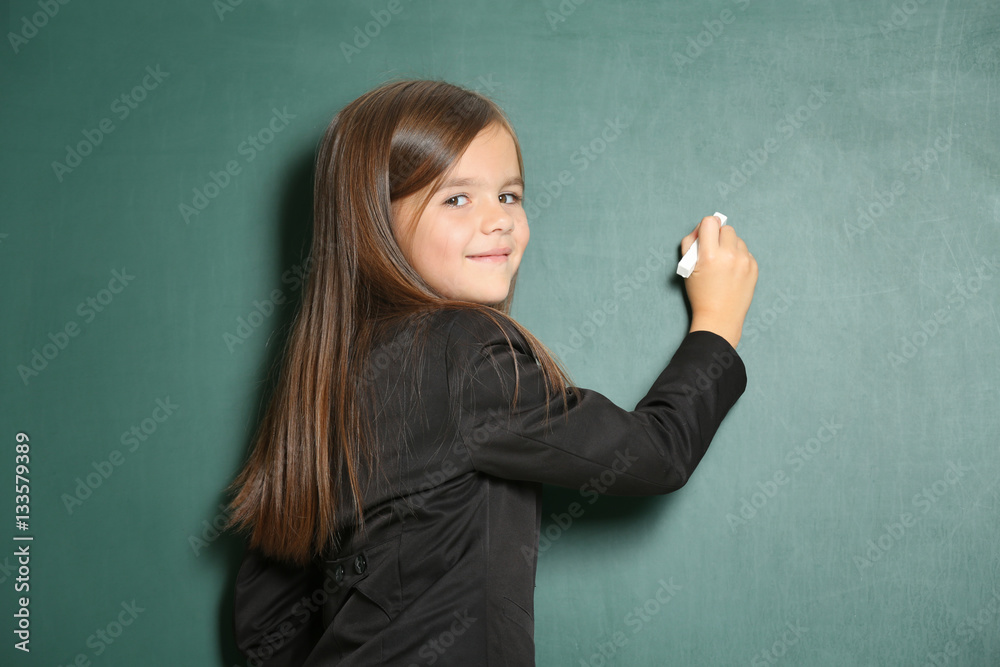 Little girl writing something on blackboard Little girl writing something on blackboard