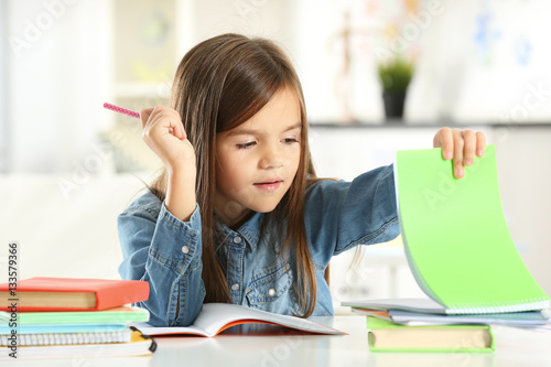 Little girl with books sitt...