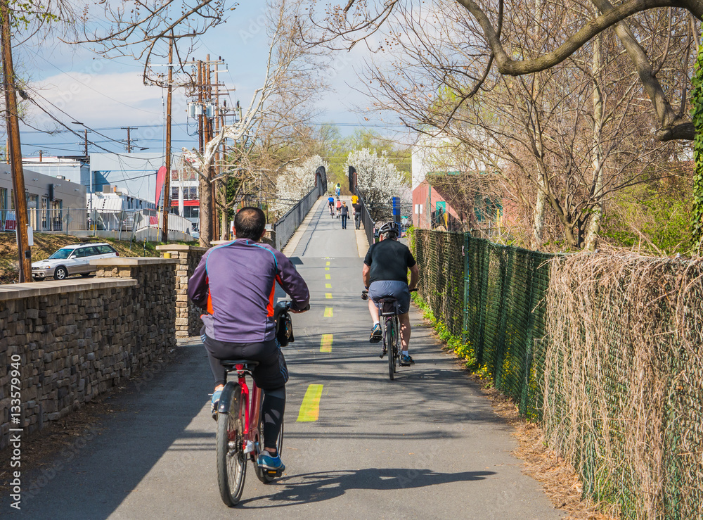Obraz premium People ride on urban bike path in city