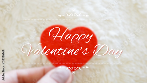 holding red heart blurred b...