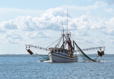 Marine shrimp fishing boat in Gulf of Mexico with nets out to catch seafood