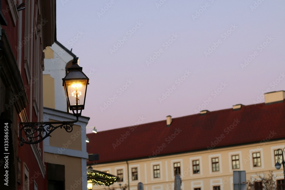 Retro lantern on Kaptol, Zagreb, Croatia. Lit at dusk. Selective focus. 