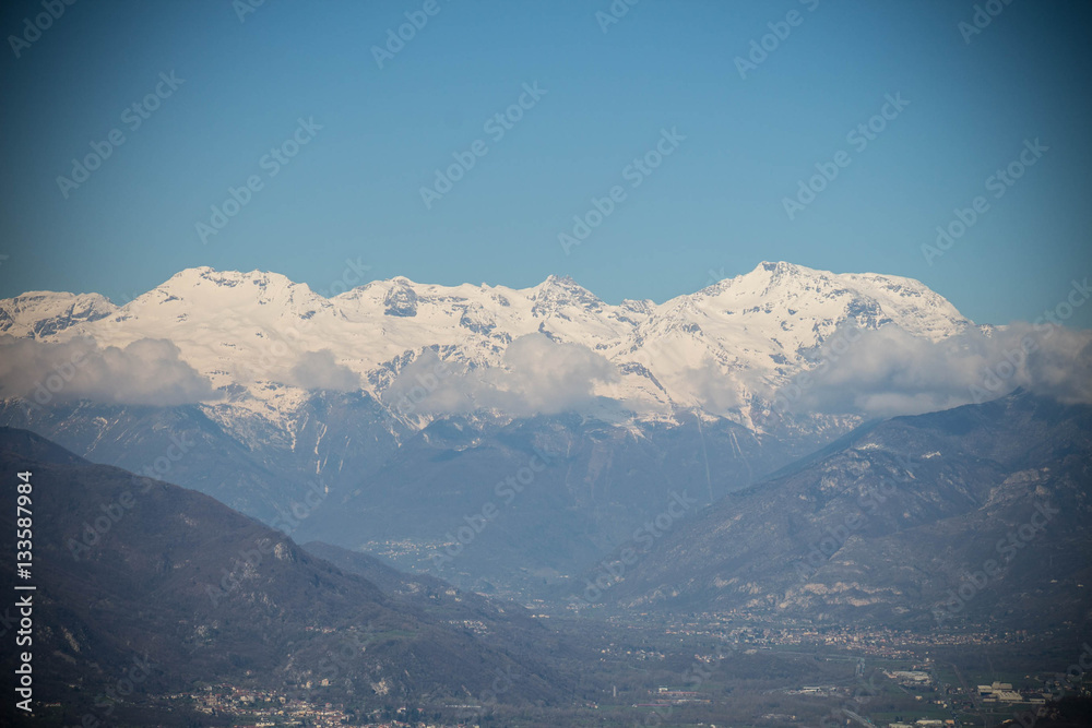 Snowy Alps and clouds in Val di Susa. Vignette effect. Piedmont. Italy