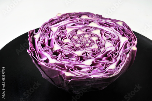 Red cabbage slice isolated on black plate