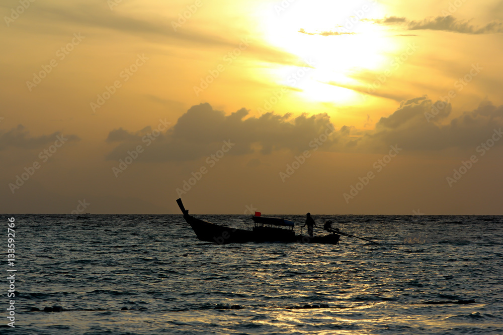 Fisherman on the boat over dramatic sunse Fisherman on the boat over dramatic sunse