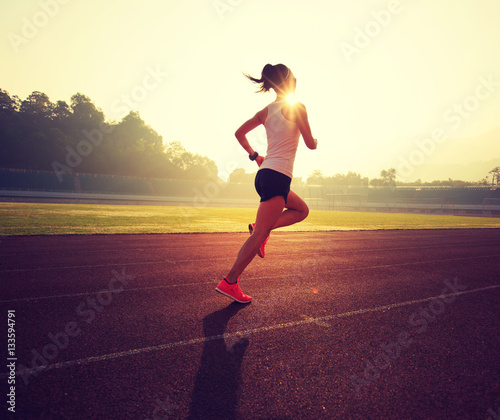 young fitness woman runner running on stadium track © lzf