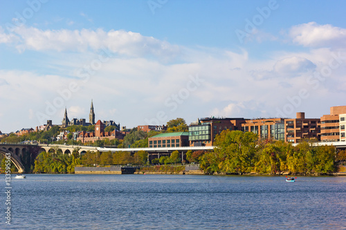 Georgetown waterfront suburb in Washington DC with a view on university historic buildings. Potomac River near Key Bridge with kayaks and motorboats.
