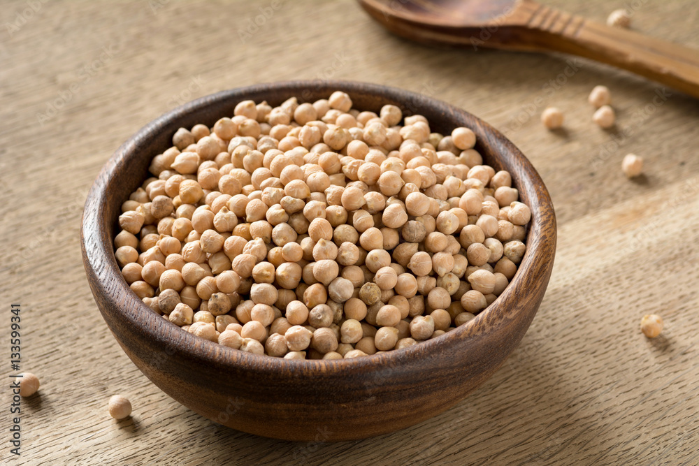Chickpeas in wooden bowl on wooden table. Vegan product for healthy lifestyle