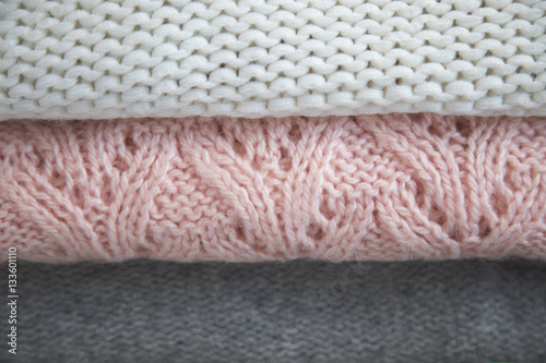 three folded sweaters white pink and grey