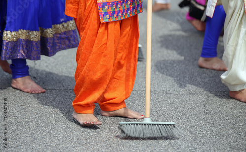 barefoot women of Sikh religion with colorful clothes sweep the