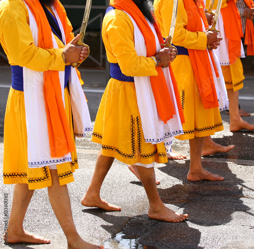 Sikh men walk barefoot through the streets